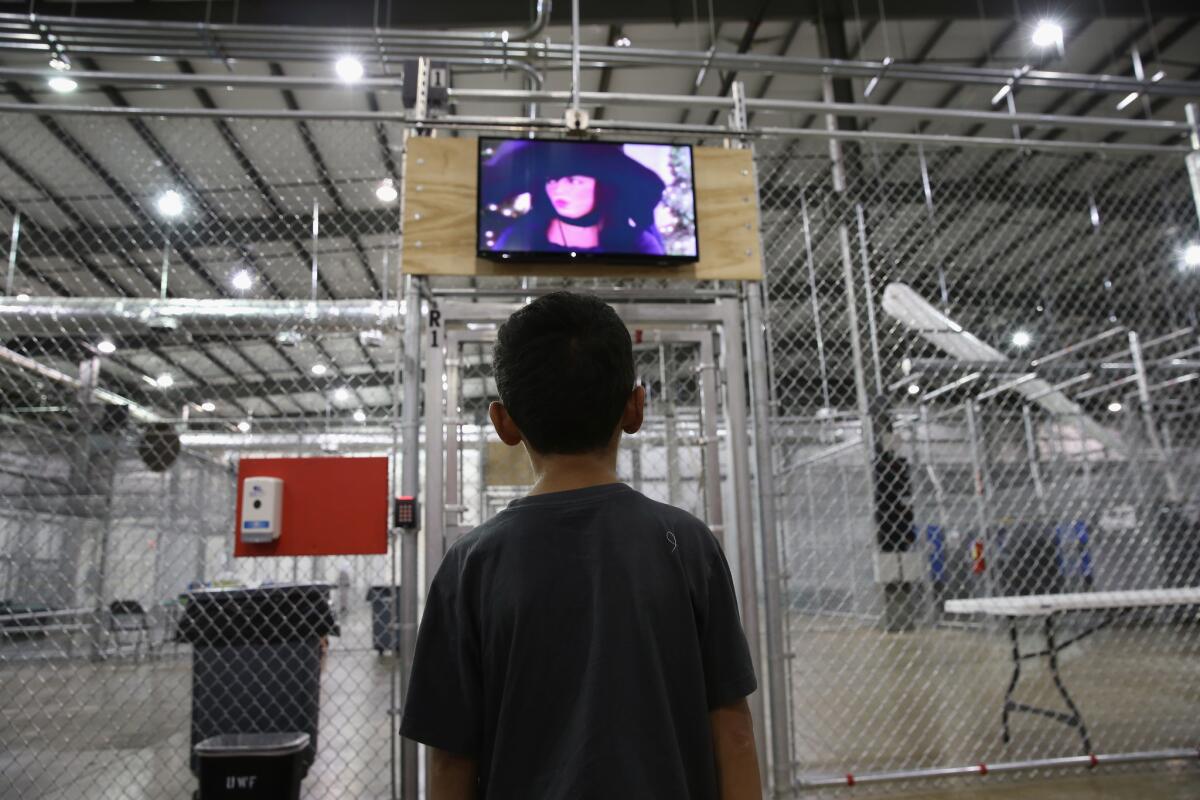 A boy from Honduras watches a movie at a detention facility run by the U.S. Border Patrol on Sept. 8 in McAllen, Texas.