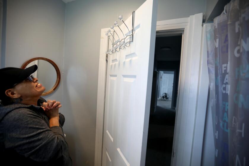 EL SERENO, CA - APRIL 5, 2024 - - Maria Merritt, 56, smiles and is pleased with her new towel rack that she hung in the bathroom in her home on Sheffield Avenue in El Sereno on April 5, 2024. Merritt, once homeless, says she celebrates the small things in her life. In March 2020, after seven decades of activism against a planned-then-abandoned freeway and at the start of a global health pandemic, Merritt and 11 other homeless and housing insecure individuals and families decided to seize empty, Caltrans-owned homes. They called themselves Reclaimers. For a two-year stretch, Merritt and the others lived in the homes legally after signing leases with the city housing authority. But those agreements have long since expired. Eviction lawsuits are proceeding in Los Angeles Superior Court, with trials scheduled for this spring. No matter the outcome, Merritt says she's not leaving again. (Genaro Molina/Los Angeles Times)