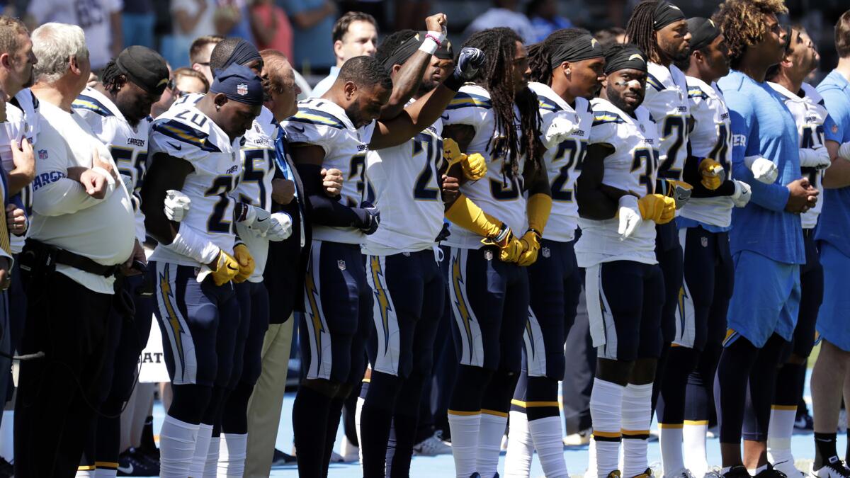 In a protest against President Trump's comments, the Chargers link arms during the national anthem before Sunday's game against the Kansas City Chiefs at StubHub Center.