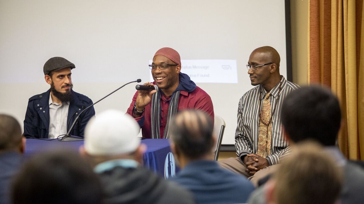 Amin Eshaiker, left, the program manager for Link Oustide, listens as Tobias Tubbs, 48, speaks about life in prison, during an Islamic Institute of Orange County meeting on Feb. 15. Also in the photo is Gernay Quinnie Jr., 37.
