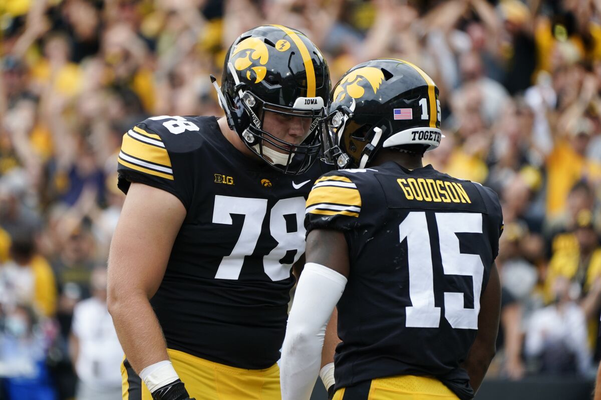 Iowa running back Tyler Goodson (15) celebrates with teammate offensive lineman Mason Richman (78) after scoring on a 56-yard touchdown run during the first half of an NCAA college football game against Indiana, Saturday, Sept. 4, 2021, in Iowa City, Iowa. Iowa won 34-6. (AP Photo/Charlie Neibergall)
