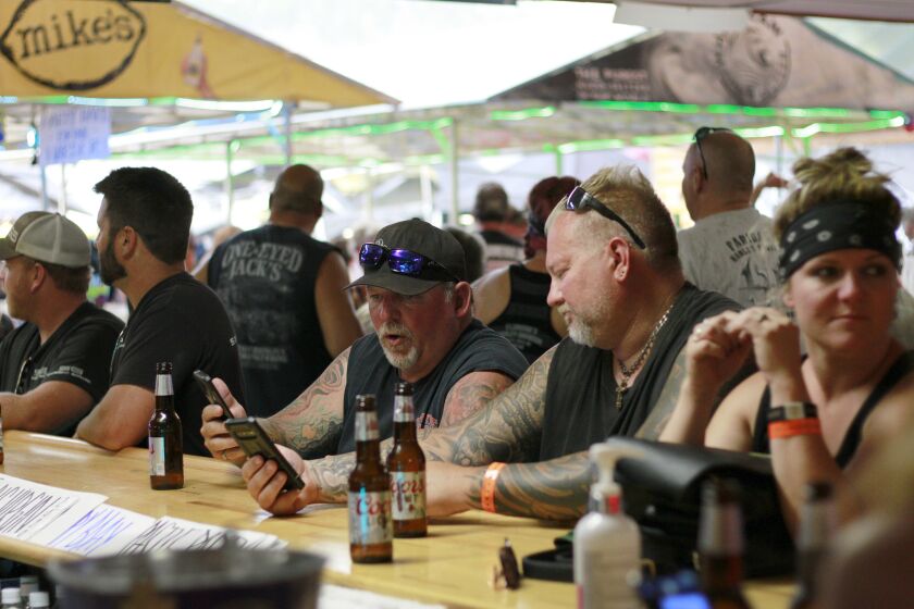 FILE - In this Aug. 7, 2020, file photo, people congregate at One-Eyed Jack's Saloon during the 80th annual Sturgis Motorcycle Rally in Sturgis, S.D. The annual Sturgis Motorcycle Rally refused to take 2020 off despite the threat of the coronavirus pandemic, a decision blamed for leading to a late-summer spike in cases across the Midwest. And it's about to roar right back this year, kicking off Friday, Aug. 6, 2021 with crowds expecting to be significantly larger even as the delta variant is rising. (AP Photo/Stephen Groves, File)