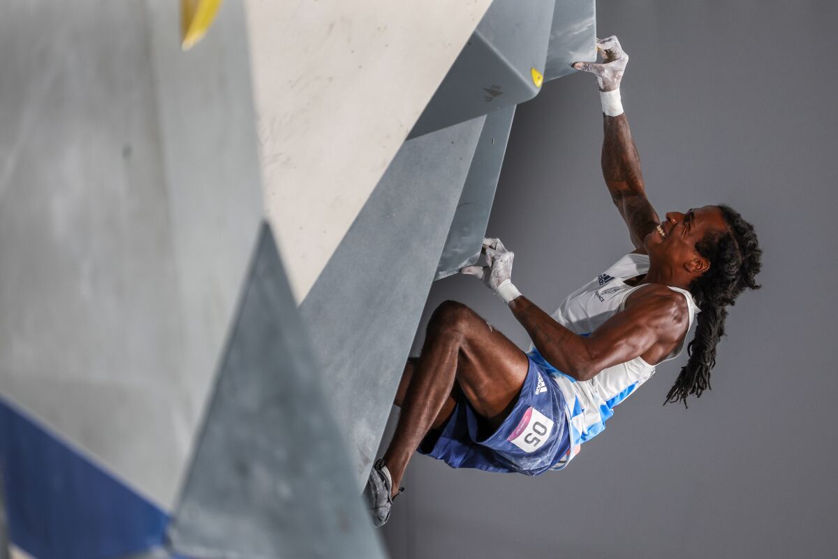 French climber Mikael Mawem uses his fingers to get through a tough part of the bouldering competition.