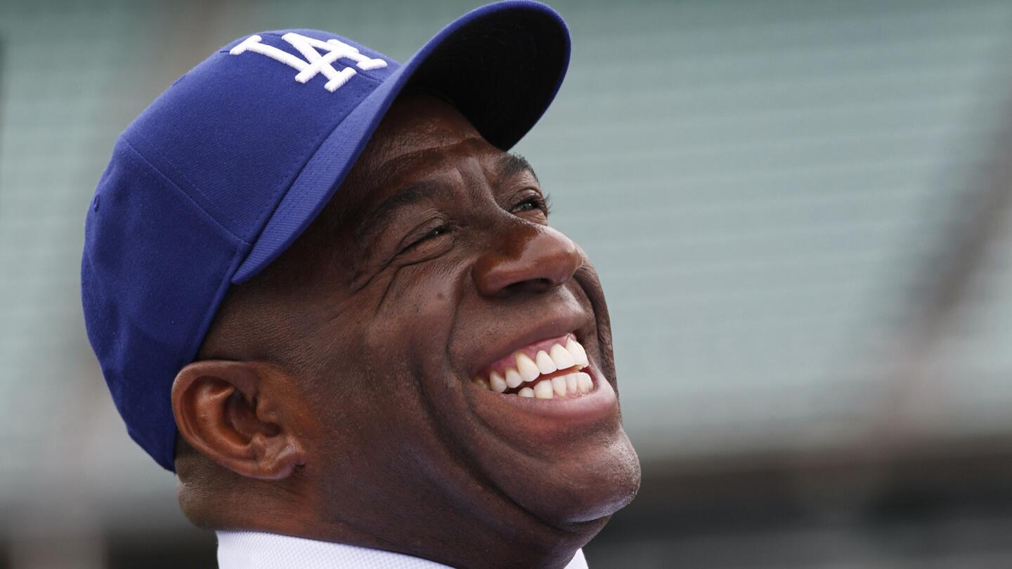 Lakers great Magic Johnson laughs while being introduced at Dodger Stadium as part of an ownership group that purchased the Dodgers in May 2012.