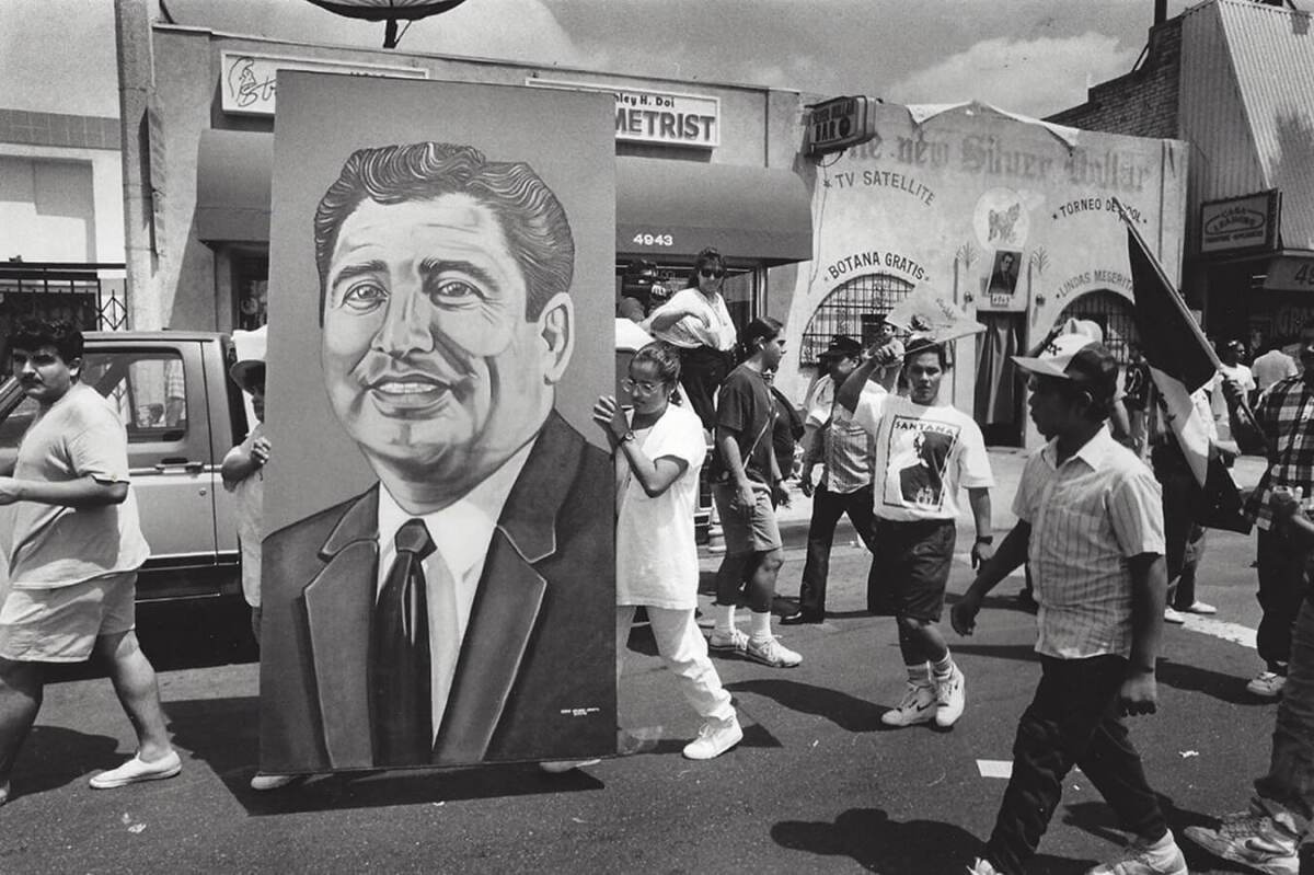 An undated photo shows a procession bearing a large portrait of the late Rubén Salazar.