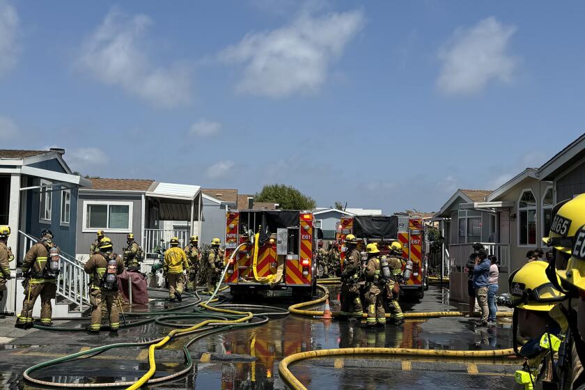 Newport Beach firefighters respond to a structure fire at the Newport Terrace Mobile Home Park Wednesday afternoon.