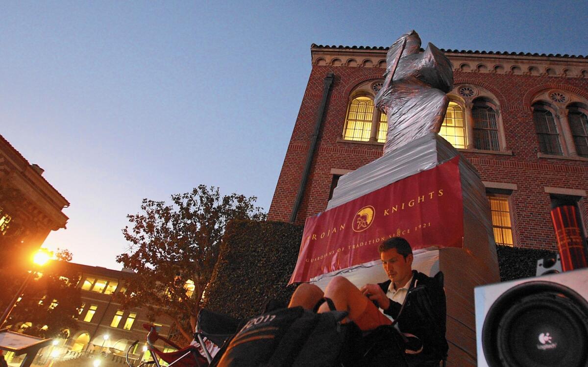 USC senior David Fine keeps watch over a tightly wrapped Tommy Trojan as Rivalry Week kicked off in 2012.