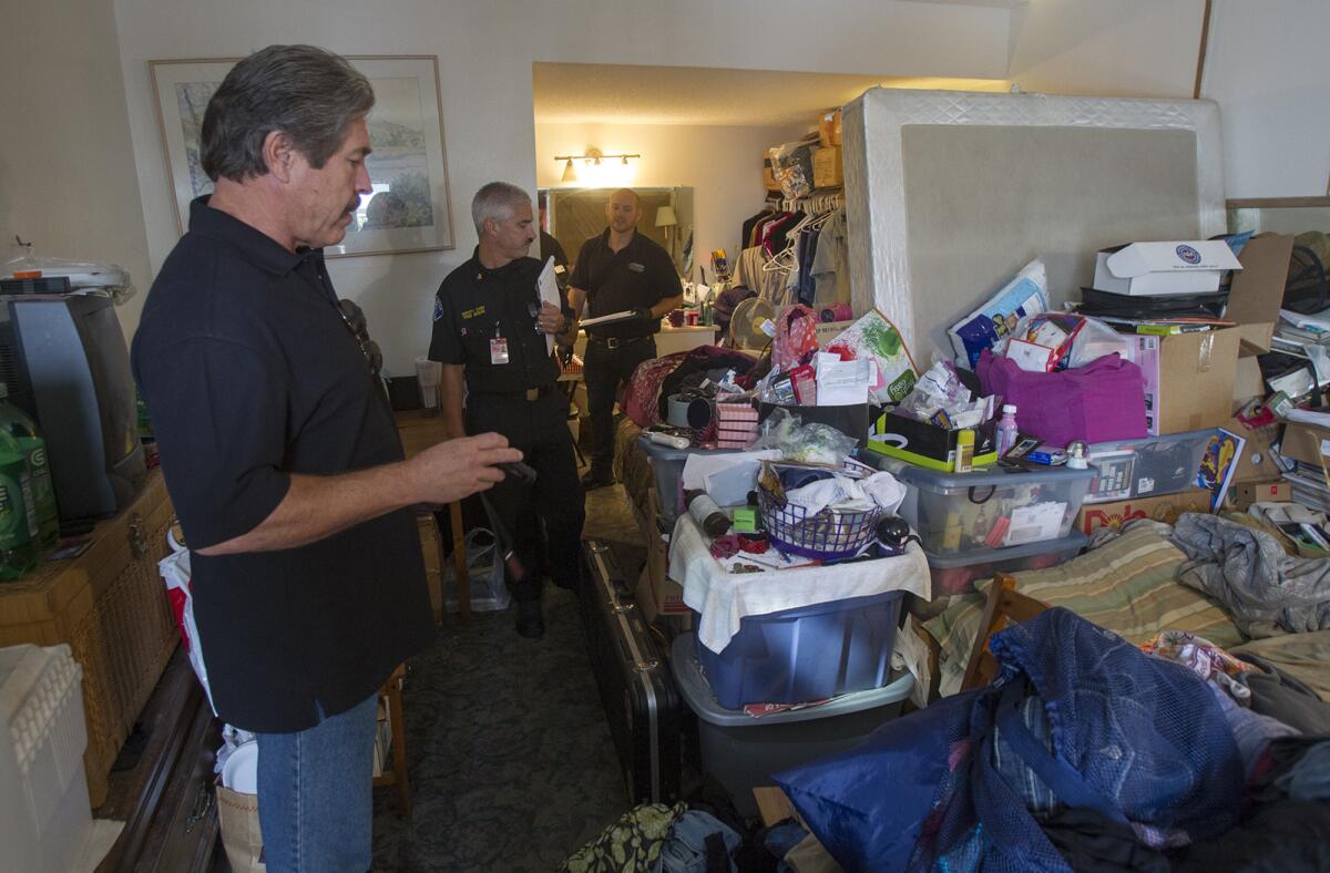 Keith Clark, left, the director of the Community Improvement Division, with Fred Seguin, center, the deputy chief with the Costa Mesa Fire Department, and code enforcement officer Jon Neal inspect a disheveled room at the Alibaba Motel in Costa Mesa.