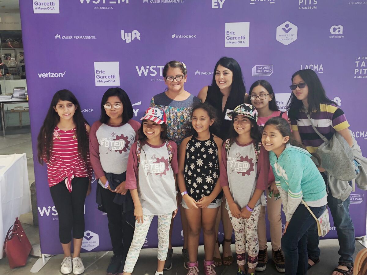 Diana Trujillo, en negro, se toma una foto con las jovencitas de un evento STEM.