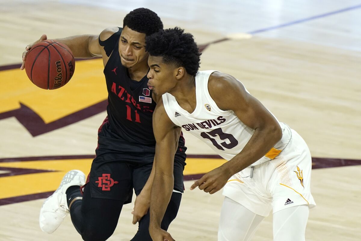 San Diego State forward Matt Mitchell collides with Arizona State guard Josh Christopher.