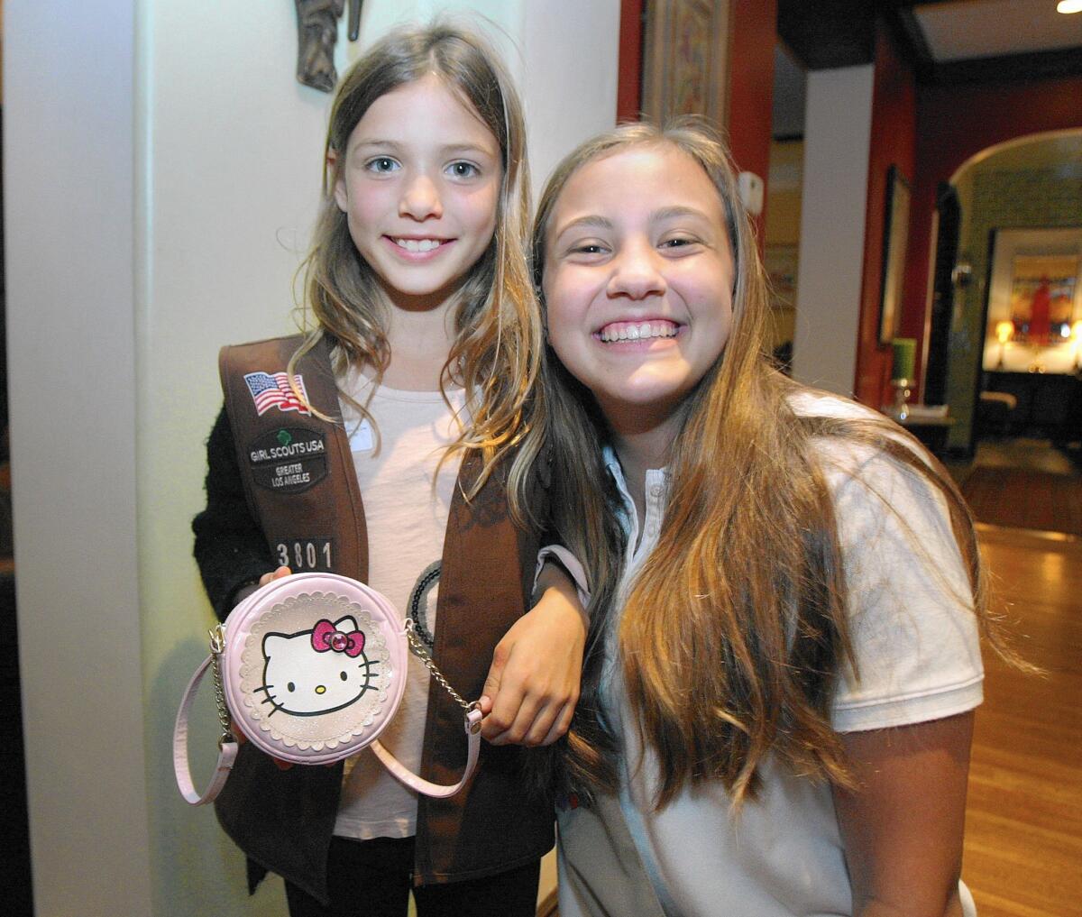 With her Hello Kitty purse in hand, Juliana Rozanski, 9, and Maddie Bohman, 14, both of Glendale, get together for a photo on Thursday.