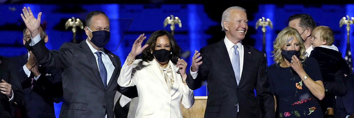 In a GIF of images, Joe Biden and Kamala Harris and their families lift their hands, clap and wave to the crowd.