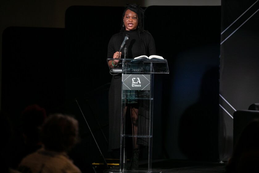 A woman stands at a lectern.