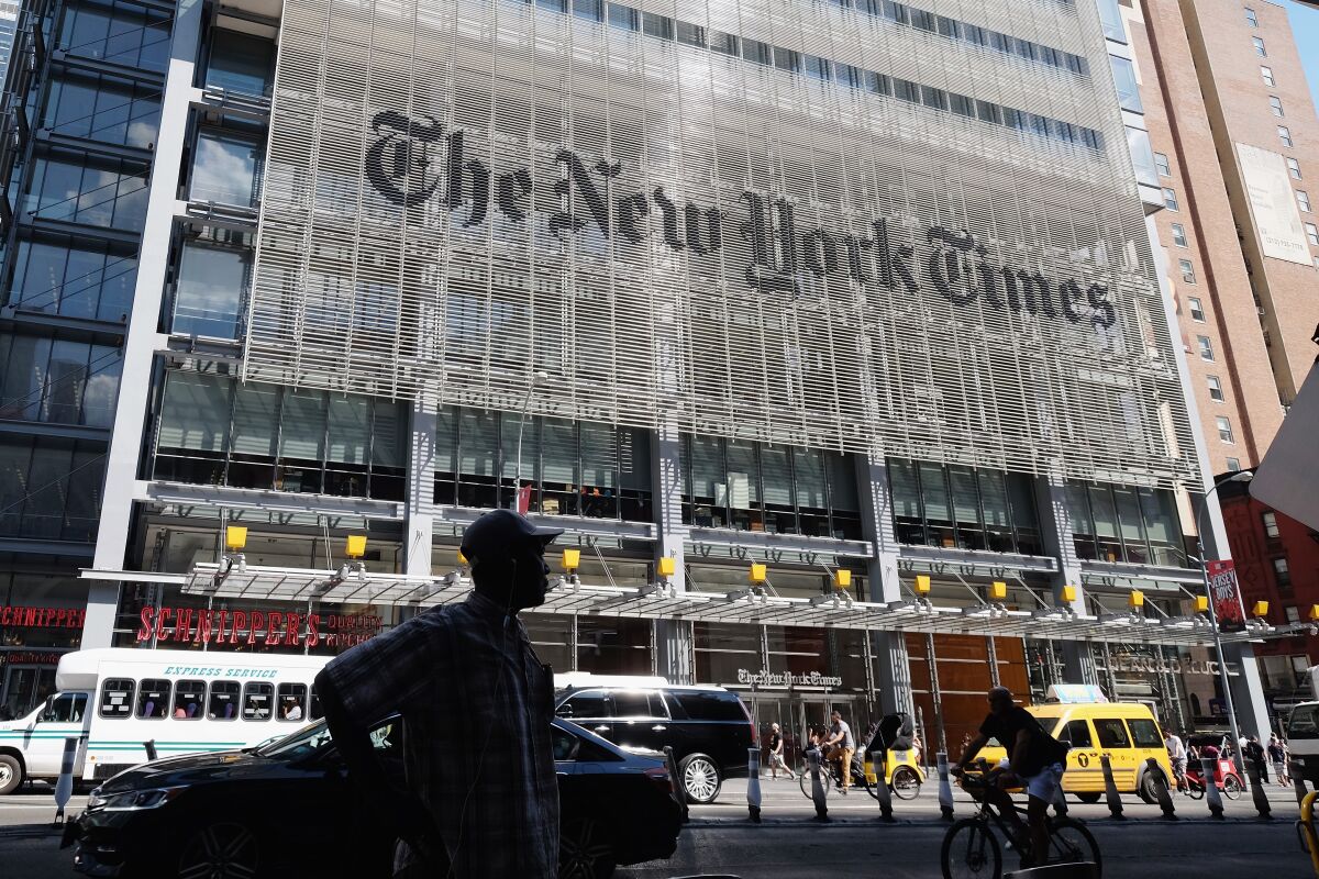 People walk past the New York Times building.
