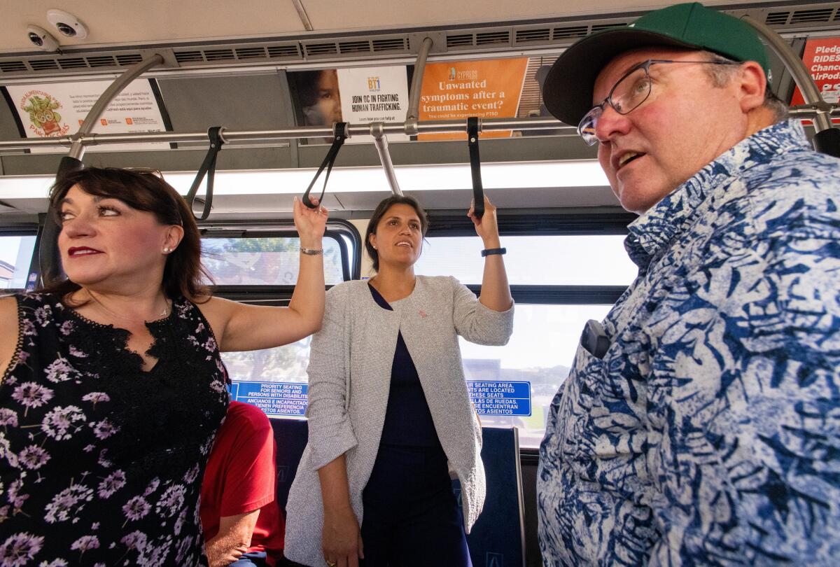 Costa Mesa employee Jennifer Rosales, Councilwoman Arlis Reynolds and Mayor John Stephens ride a bus together Friday, Oct. 6.
