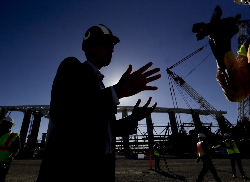 Los Angeles Rams, COO, Kevin Demoff talks with reporters at the LA Stadium construction site on Tuesday, Sept. 18, 2018, in Inglewood, Calif. The new facility for the Los Angeles Rams and Los Angeles Chargers is tentatively scheduled to be competed for the 2020 NFL football season. (AP Photo/Chris Carlson)