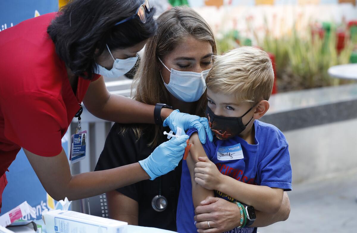 Leif Gottfred, 6, is held by his mother Danica Liberman, as he receives the children's dose of the Pfizer vaccine.
