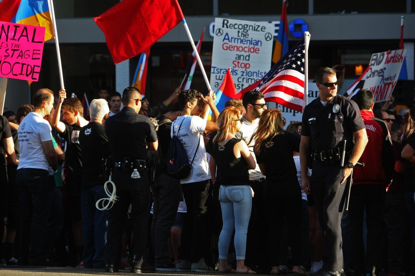 Los Angeles police officers keep watch as hundreds of Armenians protest in front of the Turkish Consulate on the 99th anniversary of the Armenian genocide at 6300 Wilshire Blvd.
