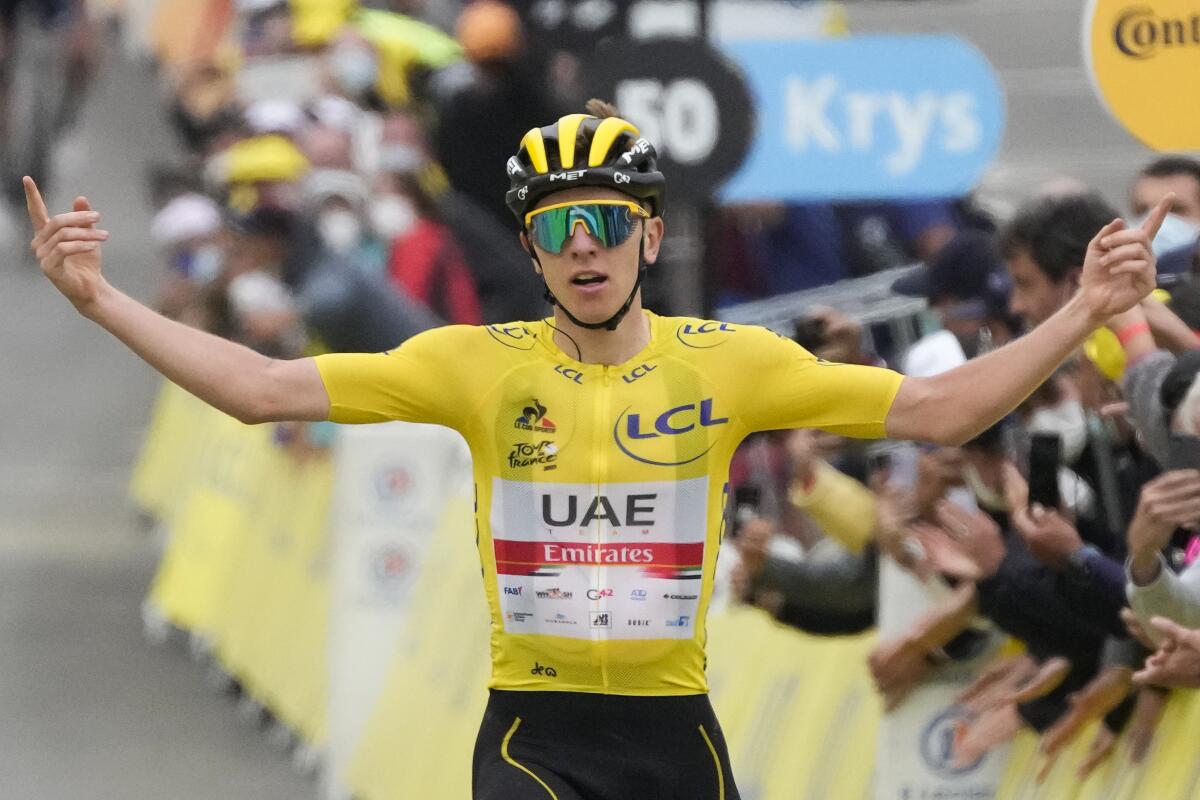 Slovenia's Tadej Pogacar, wearing the overall leader's yellow jersey, celebrates as he crosses the finish line to win the eighteenth stage of the Tour de France cycling race over 129.7 kilometers (80.6 miles) with start in Pau and finish in Luz Ardiden, France,Thursday, July 15, 2021. (AP Photo/Christophe Ena)