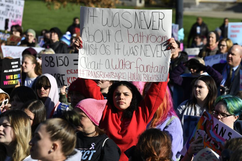 A woman holds up a sign in protest of Kentucky Senate bill SB150, known as the Transgender Health Bill, during a rally on the lawn of the Kentucky State Capitol in Frankfort, Ky., Wednesday, March 29, 2023. (AP Photo/Timothy D. Easley)