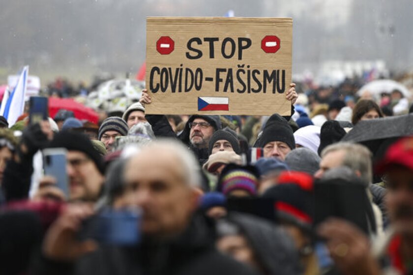 A man holds up a sign reading Stop Covid Fascism, during a protest against measures to tackle surge of COVID-19 infections, in Prague, Sunday, Nov. 28, 2021. Thousands have rallied in the Czech capital to protest the government’s restrictive measures to tackle a record surge of coronavirus infections. The protesters included supporters of a number of fringe political parties and groups that failed to win any parliamentary seats in October’s election. (Ondrej Deml/CTK via AP)