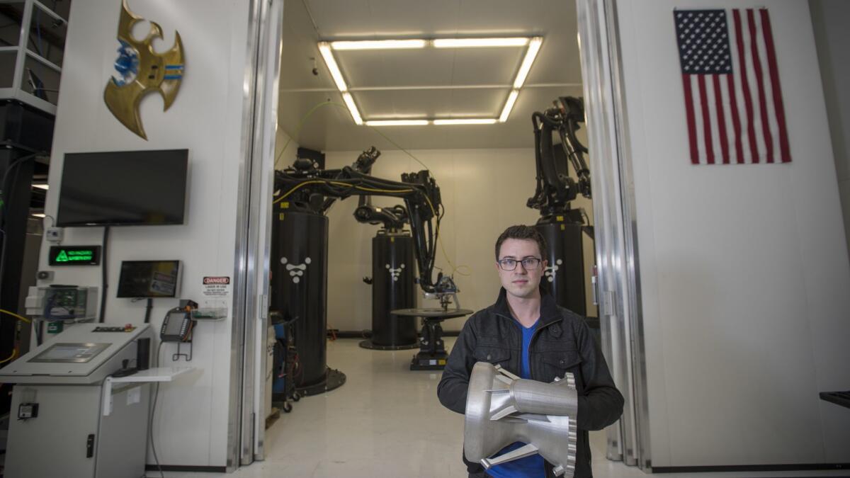 Tim Ellis, 27, chief executive of Relativity, holds a 3-D printed rocket engine nozzle made of rocket engine-grade high temperature metal.