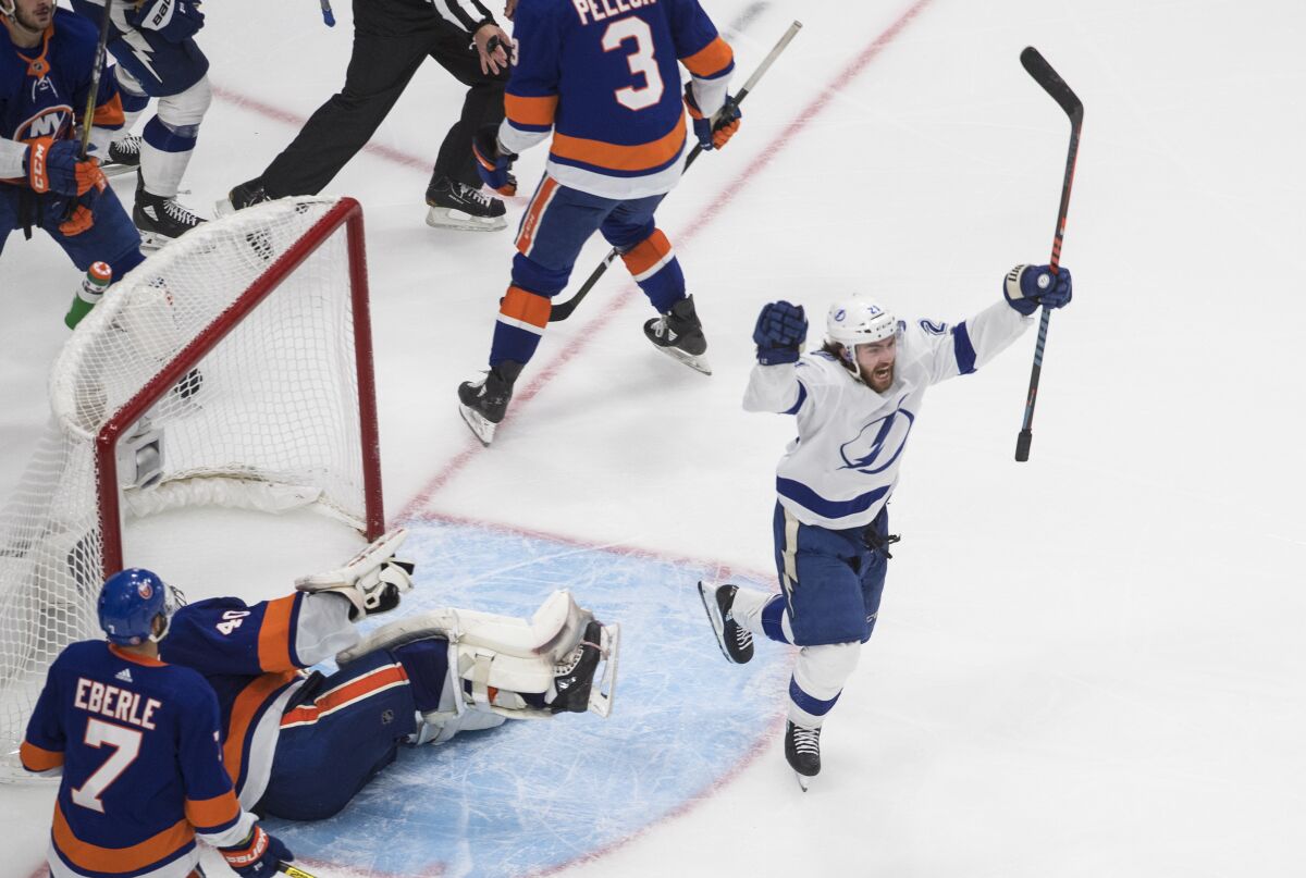 Tampa Bay Lightning's Brayden Point (21) celebrates his goal against New York Islanders goalie Semyon Varlamov (40) during the third period of an NHL Eastern Conference final playoff game in Edmonton, Alberta, on Sunday, Sept. 13, 2020. (Jason Franson/The Canadian Press via AP)