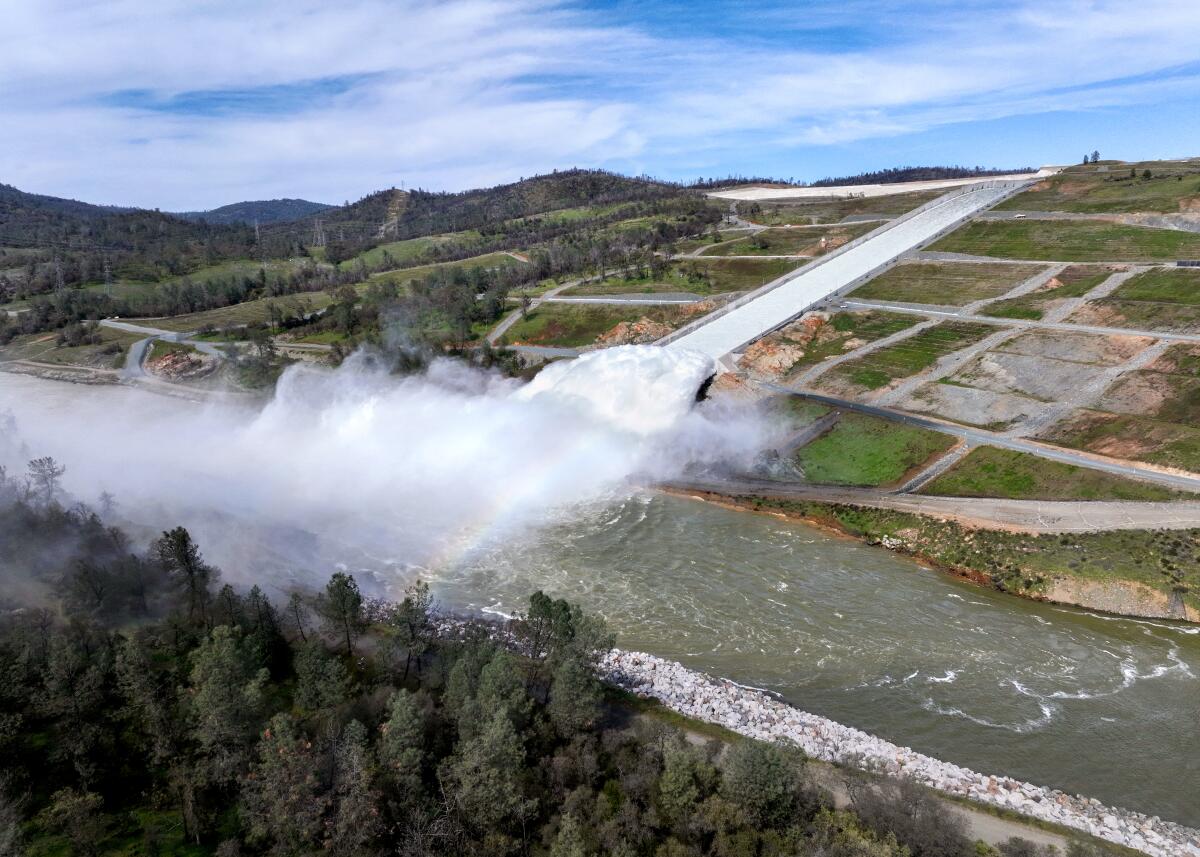 An aerial frame of cloud mist forming as water flows through a spillway down a hill.
