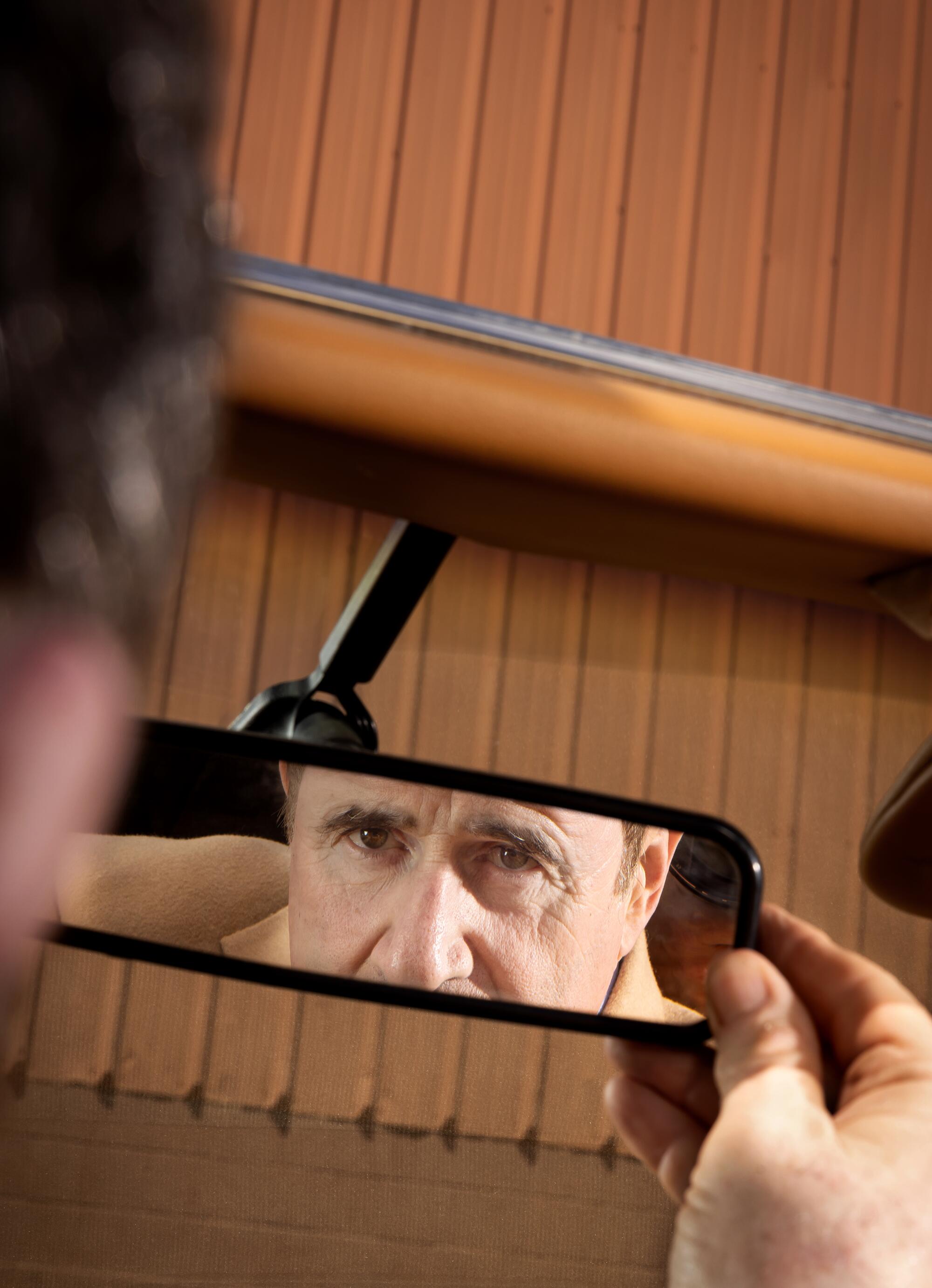 The reflection of a man's eyes in a rearview mirror