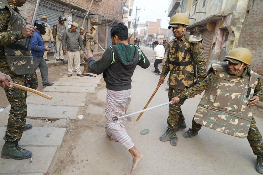 TOPSHOT - In this picture taken on December 20, 2019, police personnel clash with a protester during a demonstration against India's new citizenship law in Varanasi. - Thousands of people joined fresh rallies against a contentious citizenship law in India on December 21, with 20 killed so far in the unrest. (Photo by STR / AFP) (Photo by STR/AFP via Getty Images)