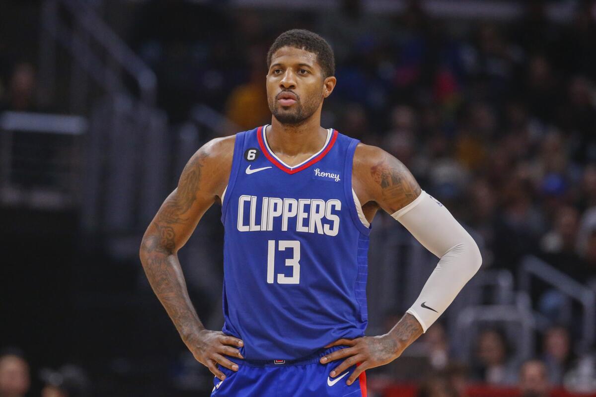 Clippers forward Paul George has his hands on his hips as he stands during a break in play.