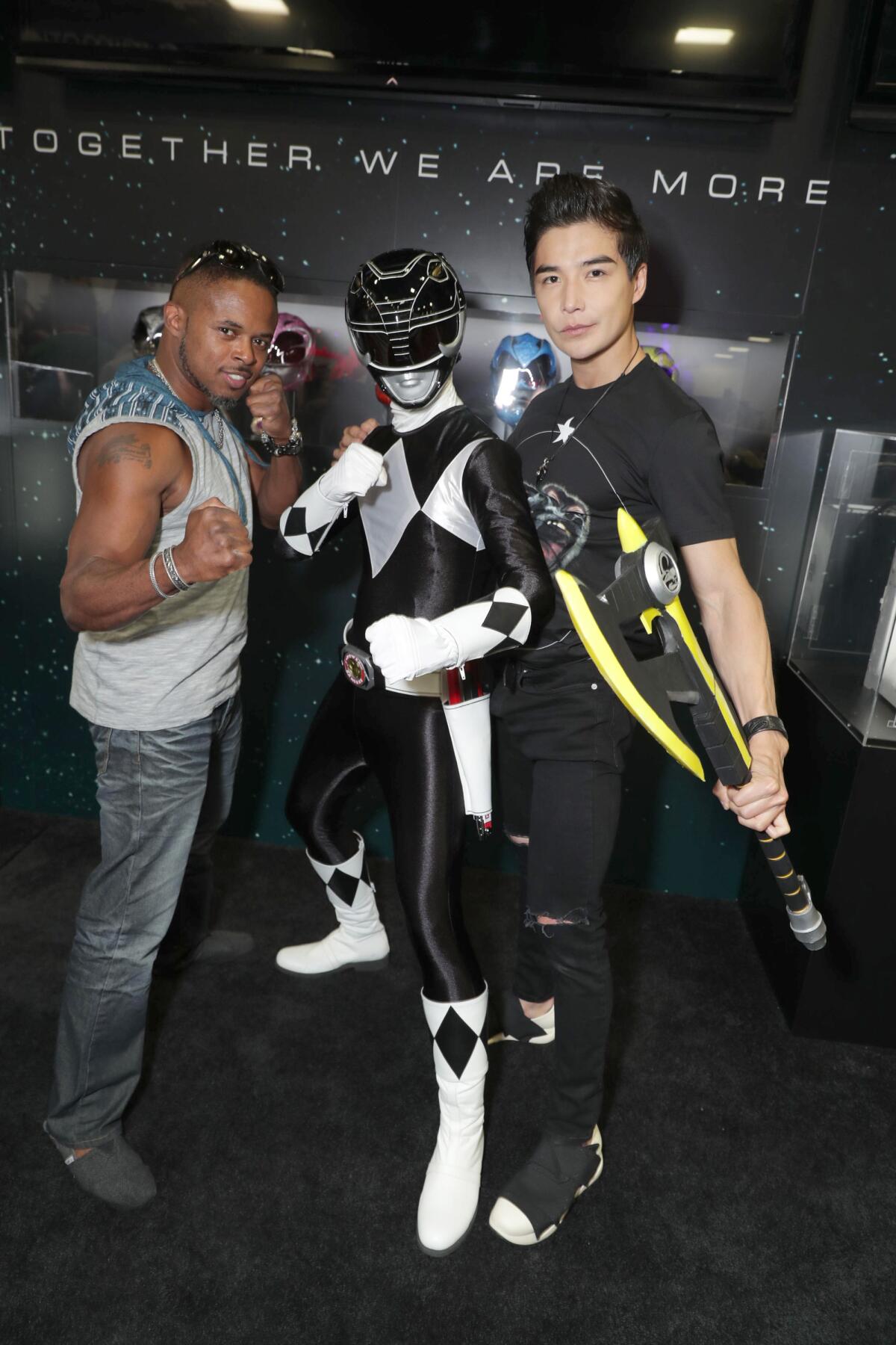 Two men pose with a black Power Ranger.