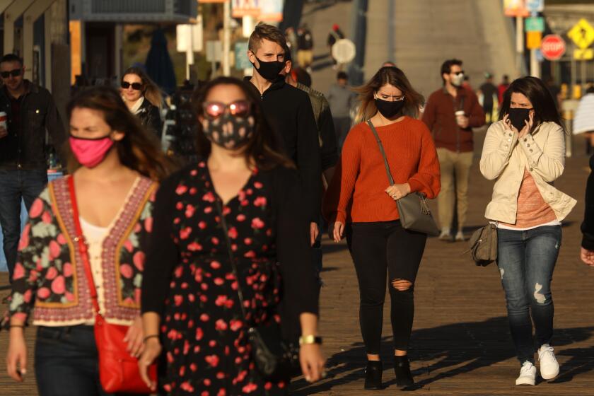SANTA MONICA, CA - NOVEMBER 09, 2020 - People, most wearing masks, walk on the Santa Monica Pier in Santa Monica on November 9, 2020. President-Elect Joe Biden reminded Americans today the importance of wearing masks. (Genaro Molina / Los Angeles Times)