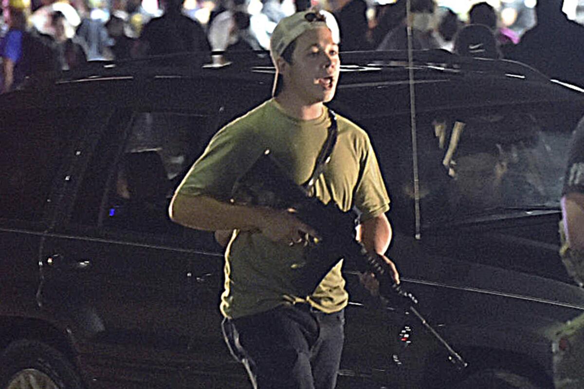 Kyle Rittenhouse carries a semiautomatic rifle in 2020.