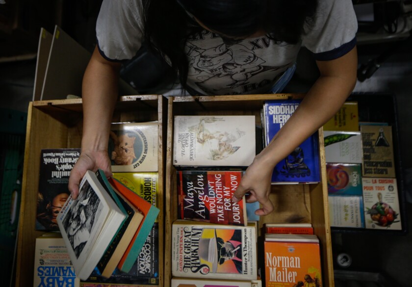 Jenny Yang looks through crates of new books to be placed for sale