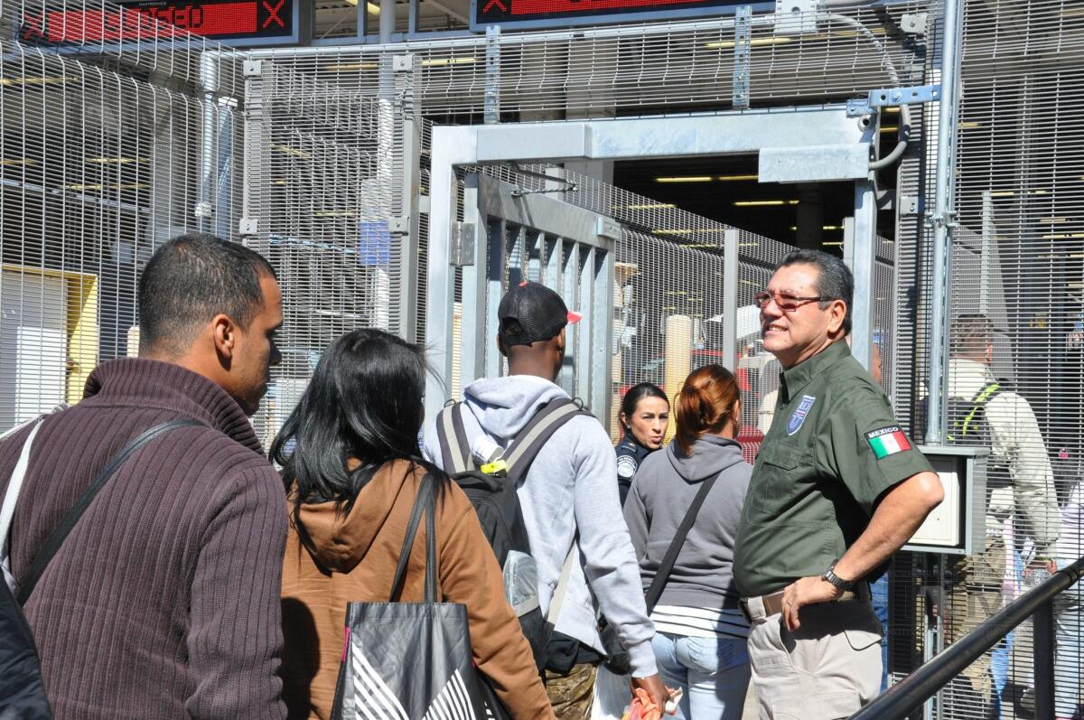 A handout photo released by National Institute of Migration shows a group of Cubans crossing a border passage between Nuevo Laredo into the U.S.