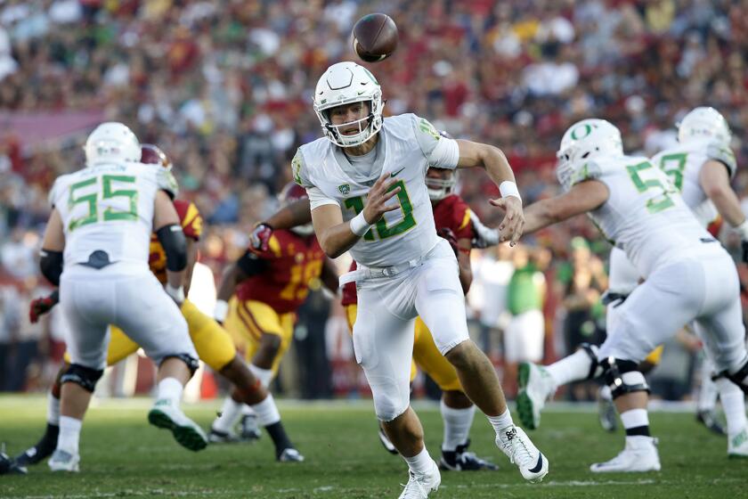 Oregon quarterback Justin Herbert chases after a bad snap leading to a sack early in the first quarter at the Coliseum on Nov. 5.