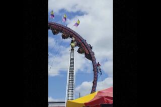 In this image made from video provided by TMX, eight people are trapped upside down on a roller coaster — some of them for more than three hours — at a festival in Wisconsin. The roller coaster's cars got stuck near the top of a loop around 1:30 p.m. Sunday, July 2, 2023, at the Crandon International Off Road Raceway in Crandon, Wis. (Scott Brass/TMX via AP)