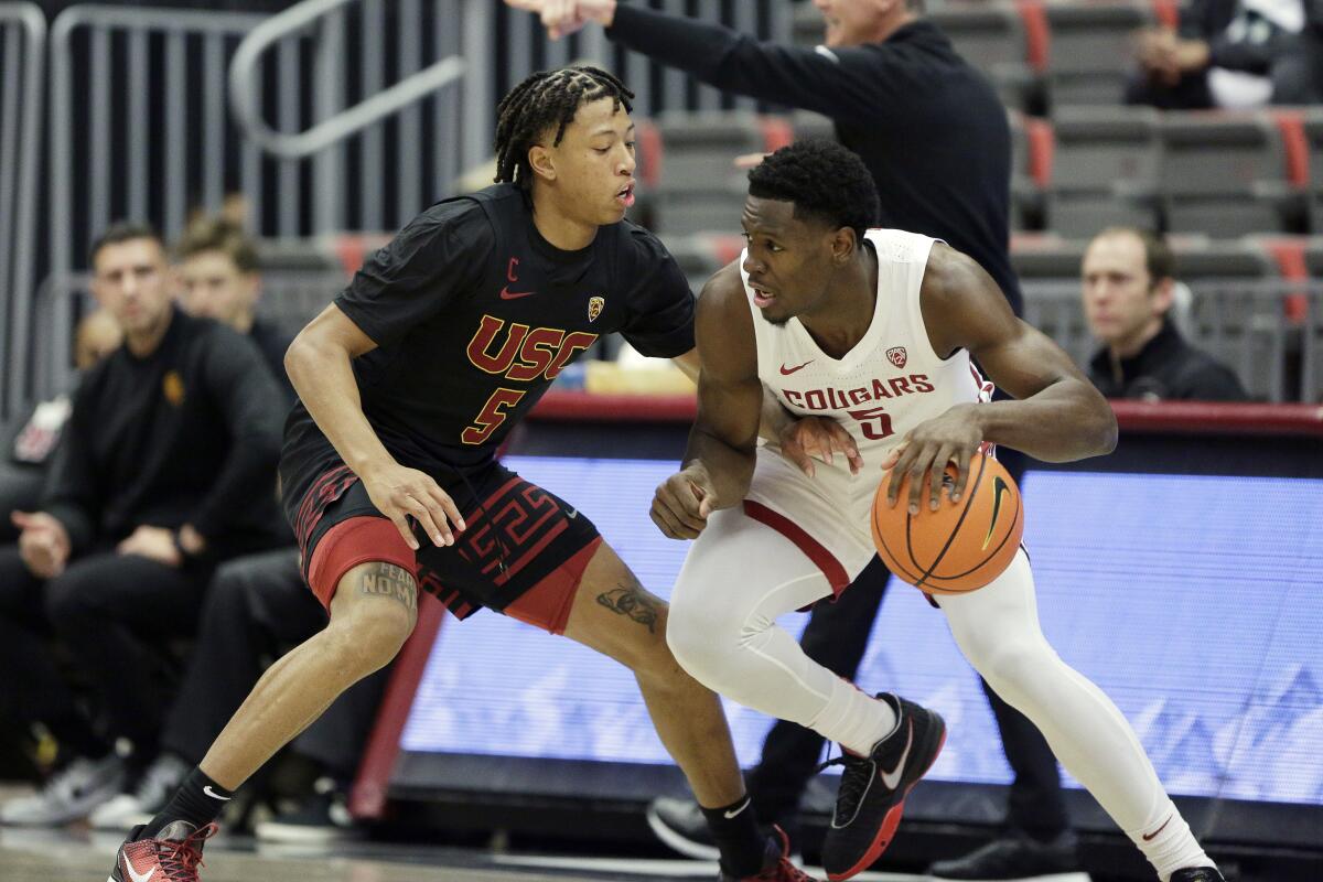 Washington State guard TJ Bamba controls the ball in front of USC guard Boogie Ellis.