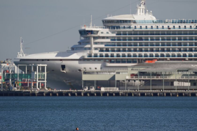 Mandatory Credit: Photo by MICHAEL DODGE/EPA-EFE/Shutterstock (10600979g) A swimmer is seen in front of the Pacific Princess cruise ship at South Melbourne beach in Melbourne, Australia, 03 April 2020. The upcoming weekend in Victoria state will see harsher social distancing laws implemented, such as a ban on all but the most basic outdoor activities. Daily life amid coronavirus pandemic, in Melbourne, Australia - 03 Apr 2020