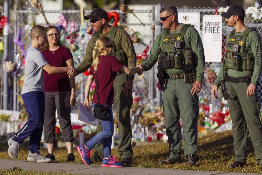 Faculty and staff greet police officers stationed outside of at Marjory Stoneman Douglas High School on Feb. 28, 2018 in Parkland, Fla.