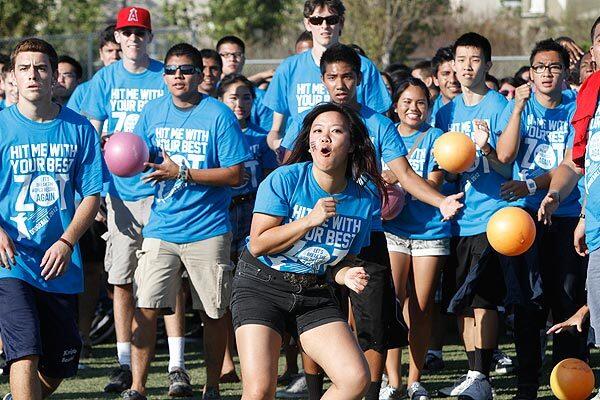 UC Irvine senior Kathy La reacts to a hit after leading the charge of the blue team in a game that set the world record for most people playing dodgeball: 6,084 players.