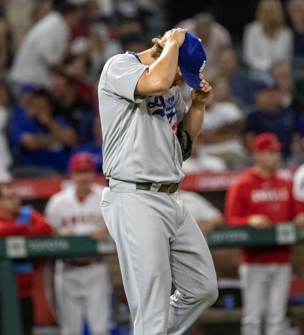 Dodgers pitcher Clayton Kershaw looks down and tightens his cap.