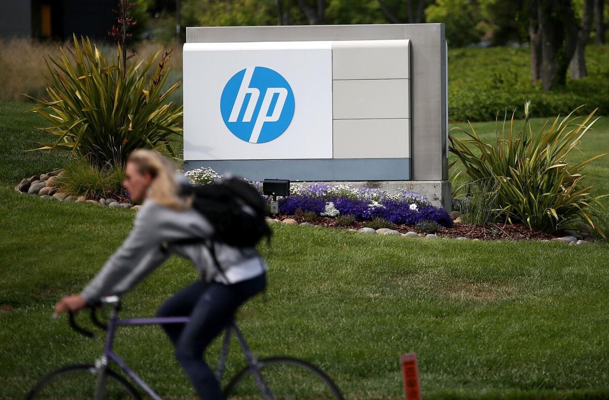 A cyclist rides by Hewlett-Packard headquarters in Palo Alto, Calif.