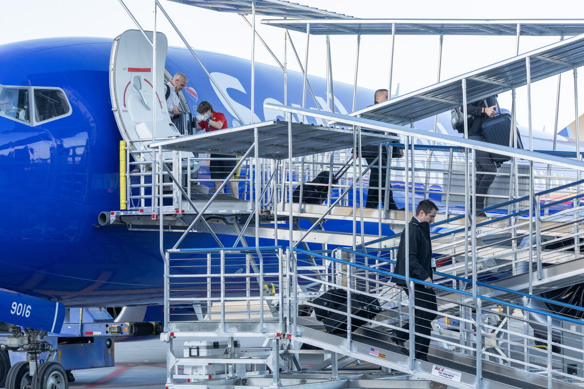 Passengers disembark from a plane.
