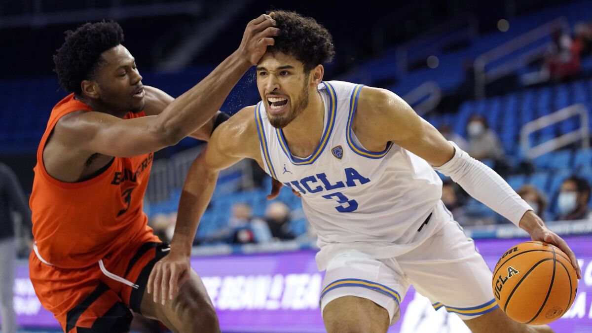UCLA guard Johnny Juzang, right, drives past Oregon State guard Dexter Akanno during the second half of an NCAA college basketball game Saturday, Jan. 15, 2022, in Los Angeles. UCLA won 81-65. (AP Photo/Mark J. Terrill)