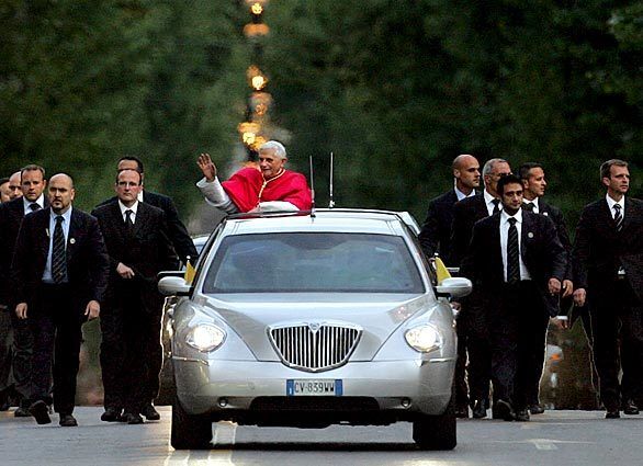Pope Benedict XVI's car is escorted by bodyguards on the way to St. Mary Major Basilica in Rome in May 2005.
