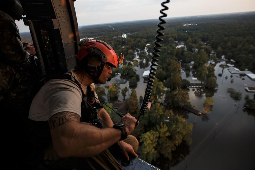 LUMBERTON, TEXAS -- THURSDAY, AUGUST 31, 2017: California Air National Guard 129th rescue wing's Master Sergeant Adam Vanhaaster searches for survivors or possible evacuees as they fly over flooded residential neighborhoods near Lumberton, Texas, on Aug. 31, 2017. (Marcus Yam / Los Angeles Times)