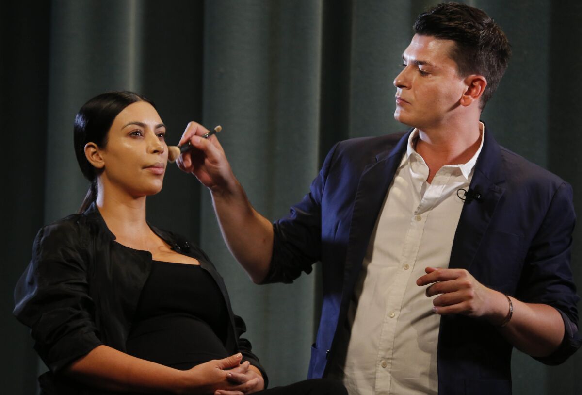 Celebrity makeup artist Mario Dedivanovic applies Kim Kardashian's makeup at the seminar at the Pasadena Civic Conference Center on Saturday.