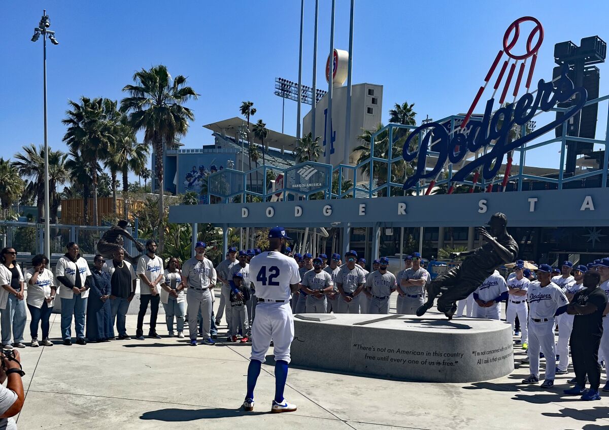 Dodgers dış saha oyuncusu Jason Heyward, Jackie Robinson heykelinin önünde oyuncular ve topluluk liderleriyle konuşuyor.